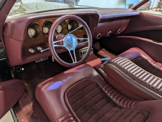Burgundy classic car interior with the dash and gauges detailed by Grindtime